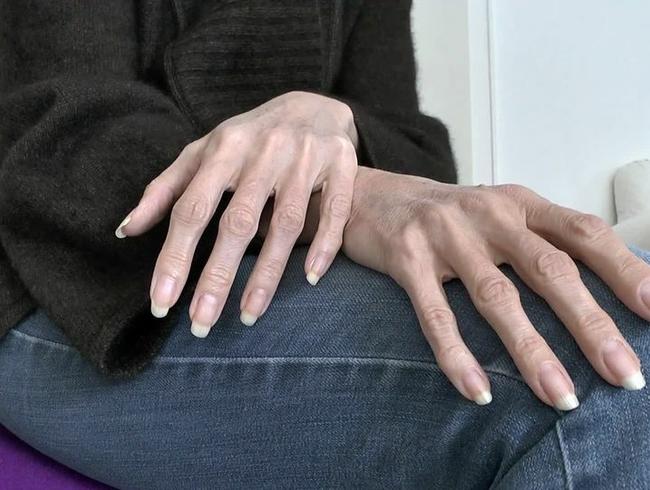 Lange natürliche Fingernägel Nahaufnahmen auf Jeansbeinen